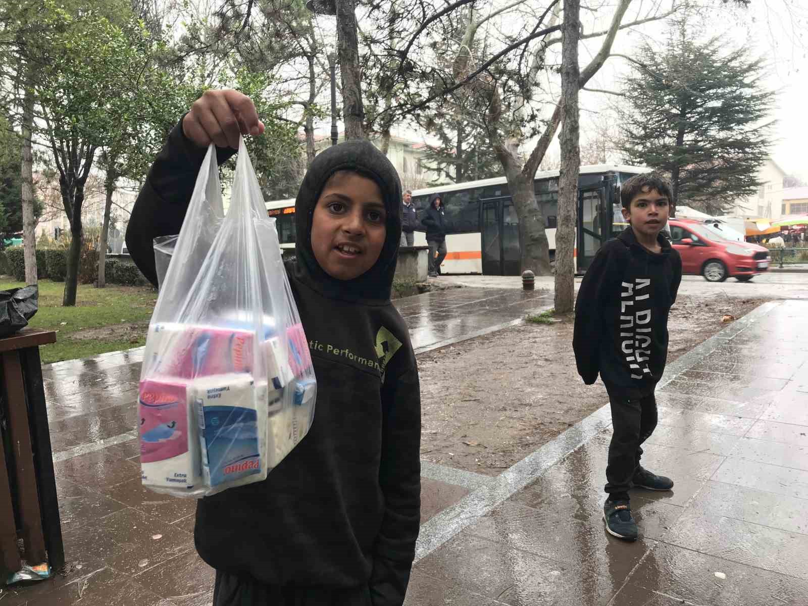 Çocuklar, yağmur altında mendil satmaya devam etti